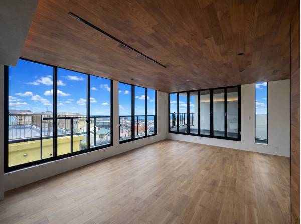 海と空を望むワイドサッシが並ぶ開放的リビングダイニング空間。