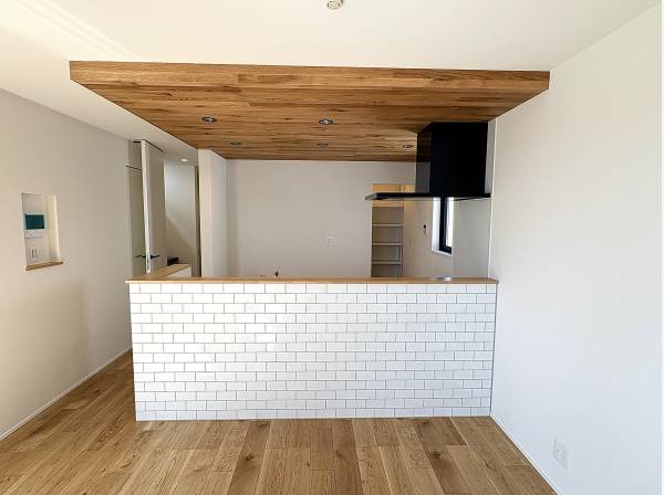 白いレンガ調のタイルと、天井の板張りが目を惹く対面式キッチン