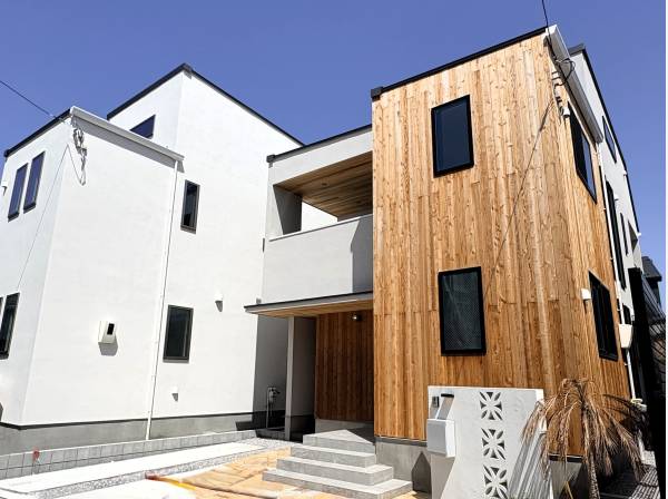 木目と白のコントラストが青空に映える、スタイリッシュな外観