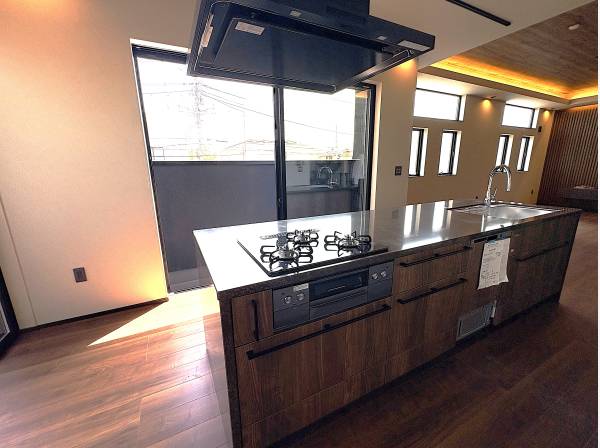 ステンレス天板が輝くアイランドキッチン。テラスとつながる開放的な空間