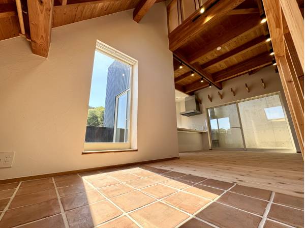 陽だまりが広がるタイルスペースと木の温もりある空間。