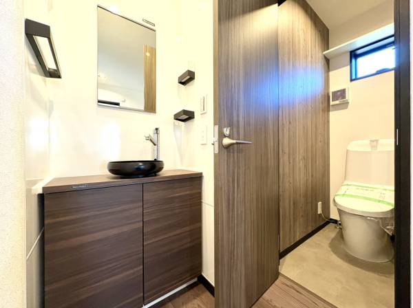 モダンなボウル型洗面台とトイレエリア。