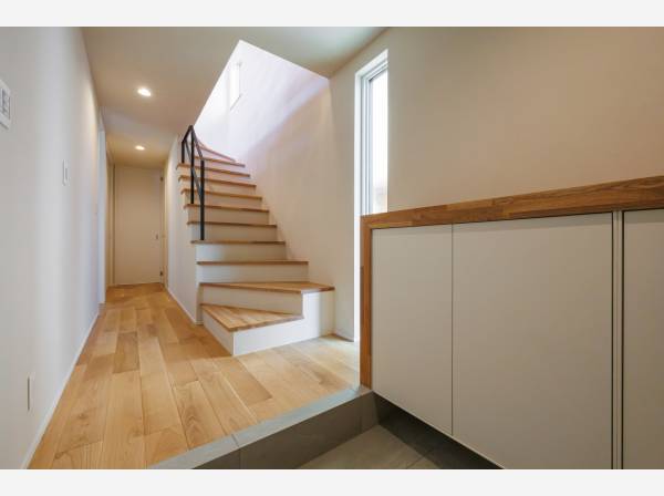 光が導くエントランス。木の温もりと直線美が印象的な、心地よく迎え入れる玄関空間。