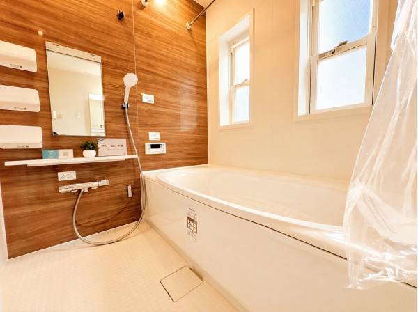 窓付きで換気も良好、木目パネルが映える上質バスルーム。