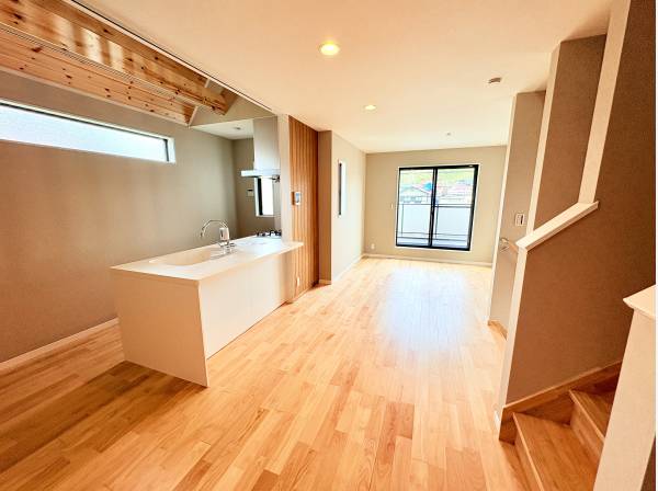 ハイサイドライトから差し込む光。木の梁がアクセントの明るい空間