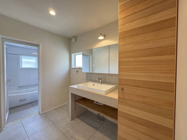 洗面台は造作仕上げ。収納の化粧板は木の柔らかな風合いでまとめました。