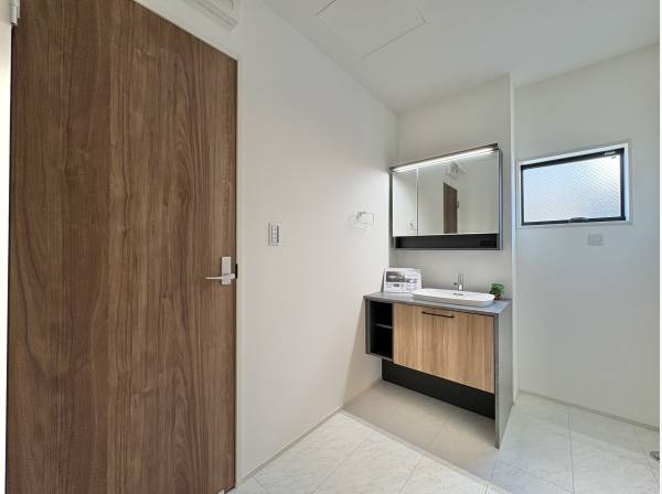 木目の建具がアクセントになる、落ち着いた洗面室。