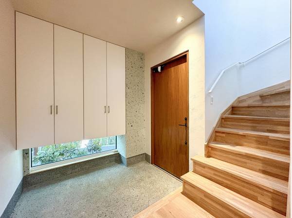 広々としたエントランス、足元の小窓からは自然光と緑が