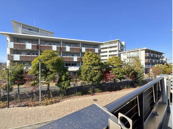 前面には広い歩道沿いに樹木が植えられ緑を感じられます