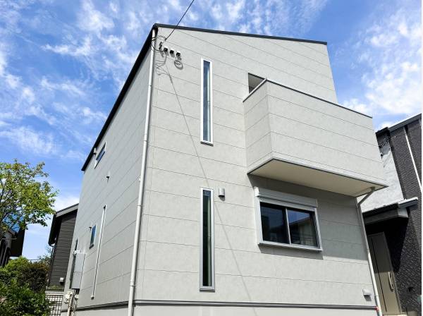 さりげなく格子の入った白亜のお住まいが周りの緑に映えます