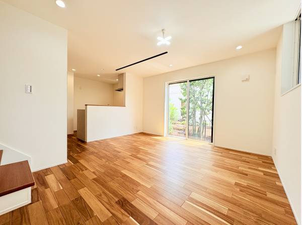 木目の美しい床が広がるリビング。窓から光が差し込む明るい空間です