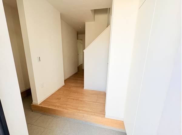 白を基調とした明るい玄関。木の温もりがご家族を優しく迎えます