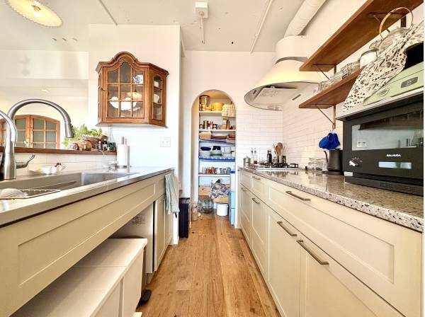 オーダーメイドの使い勝手の良いキッチン、アーチ壁の先にはパントリー