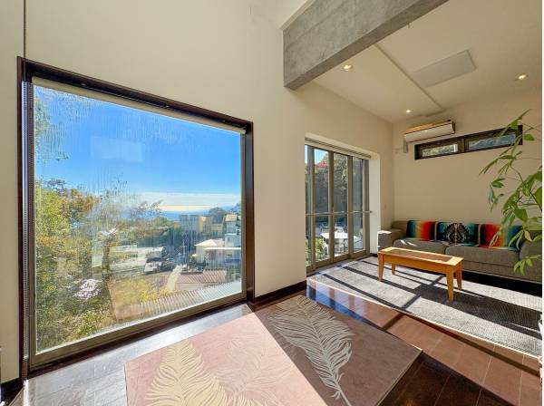 大開口の窓から美しい海と山並みを眺めます