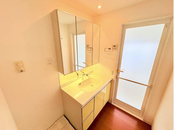 収納力のある三面鏡の洗面化粧台。扉付きで採光・換気もしやすい空間です