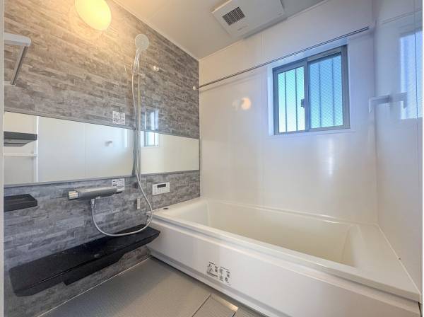 ライトグレーのバスルームはゆとりある広さ