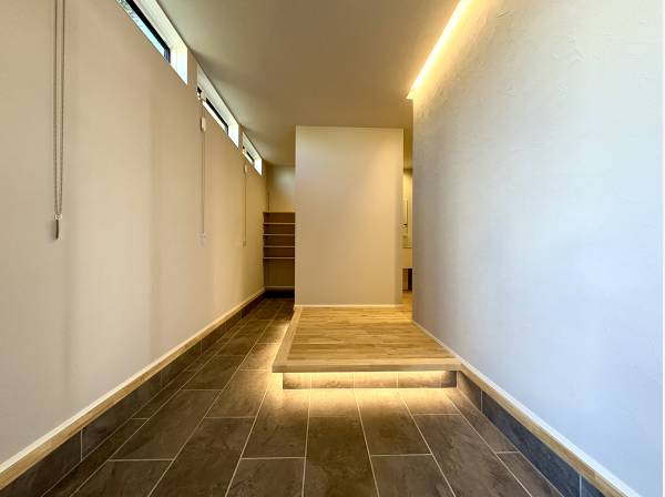 静かな光に導かれながら住まいへと気持ちがすっと切り替わる玄関空間