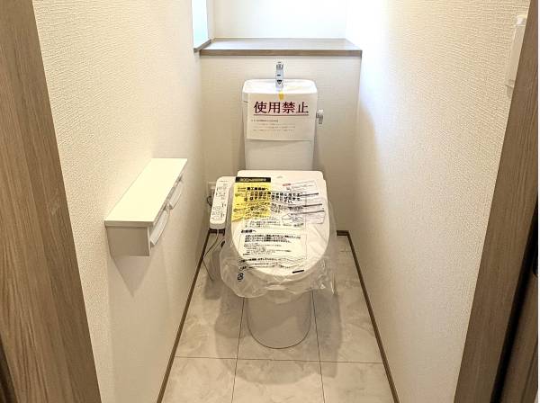 清潔感溢れる洗浄便座付きトイレ。小物を置ける棚も