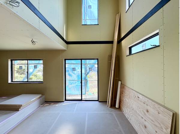 吹き抜けの窓から優しい光が差し込むリビング