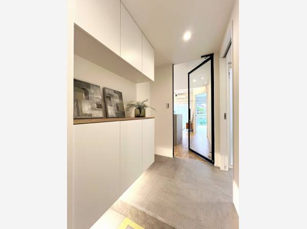 スケルトンの建具でリビングとのつながりを感じられる玄関