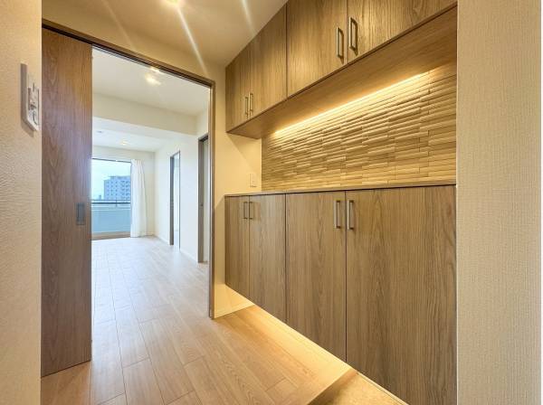 フットライトの明かりが夜の帰宅を出迎える洗練されたエントランス