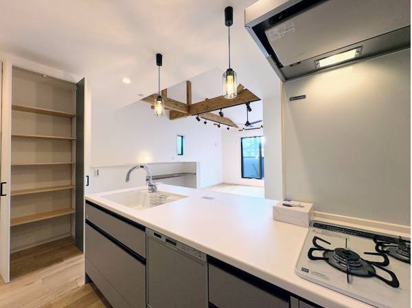 家族の顔が見える対面式キッチン、奥には大型のパントリーも