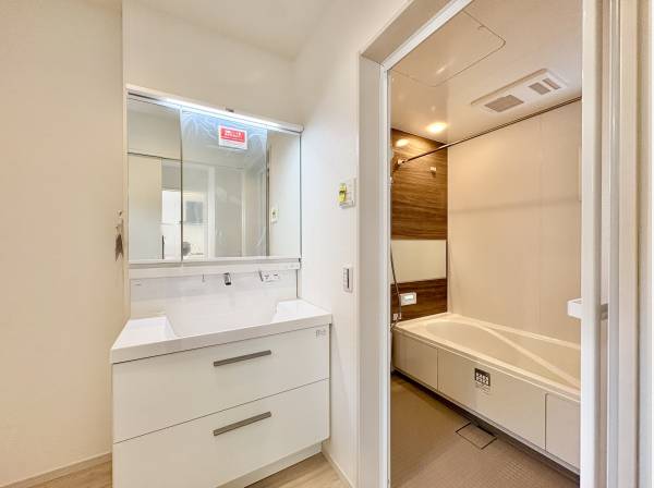 洗面室は白を基調とした清潔感のある空間。三面鏡の裏には十分な収納