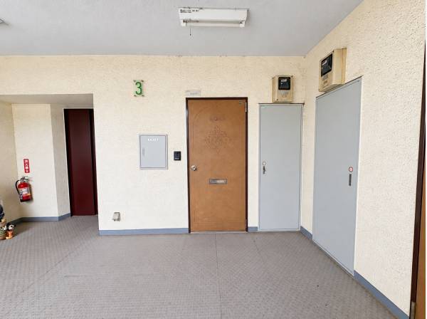装飾のある玄関扉が印象的な、落ち着いた雰囲気でご家族を迎える共用廊下。