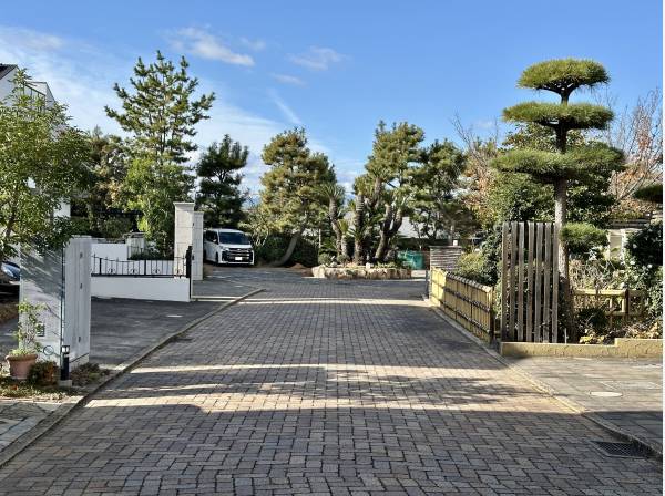 前面道路はインターロッキング敷で、周辺には邸宅が立ち並ぶエリアです