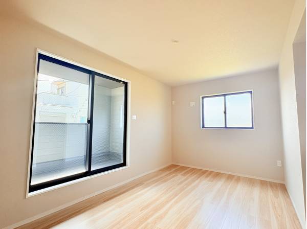 大きな窓から明るい光が差し込む洋室。バルコニーへも出られます