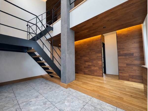 吹抜とアイアン階段が映えるデザイン性の高いエントランス空間。