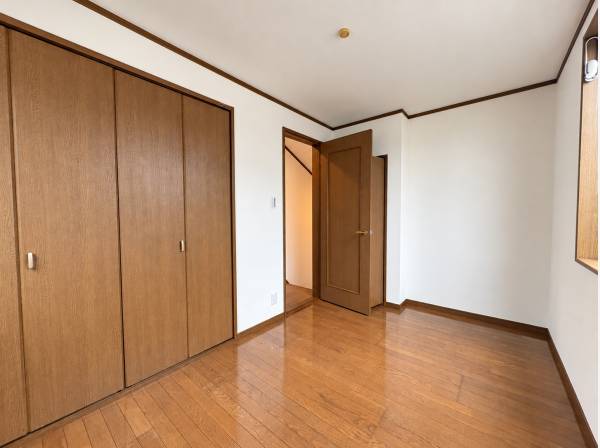 壁面の収納でお洋服を整理しやすい、木目の床が落ち着きを添える洋室です。
