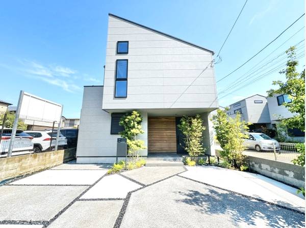 植栽と木目調のアクセントが映える、モダンで美しい建物外観