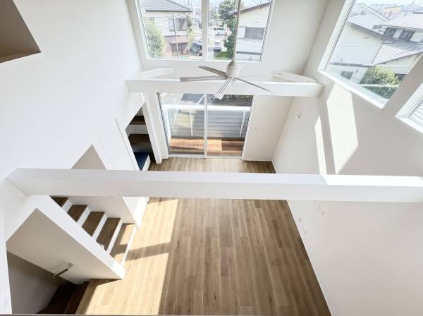 吹き抜け天井から差し込む陽光が、部屋全体を温かく包み込みます。
