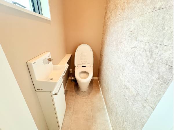 石目調タイルの壁が質の良い空間を演出。手洗い器付きの清潔なレストスーム