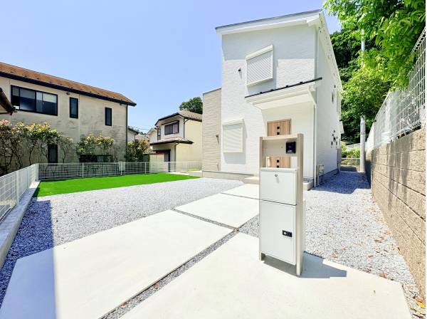 青空に映えるスタイリッシュな外観　人工芝のお庭は家族の憩いの場に！