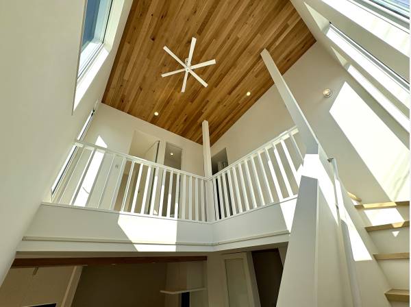 リビングから見上げれば吹抜。木目天井とファンが心地よい空間。