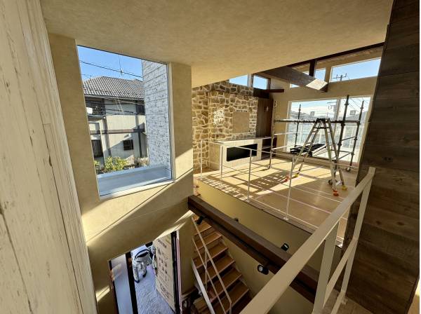 光が降りそそぐ大空間。古材と石壁が家族を迎える玄関。

