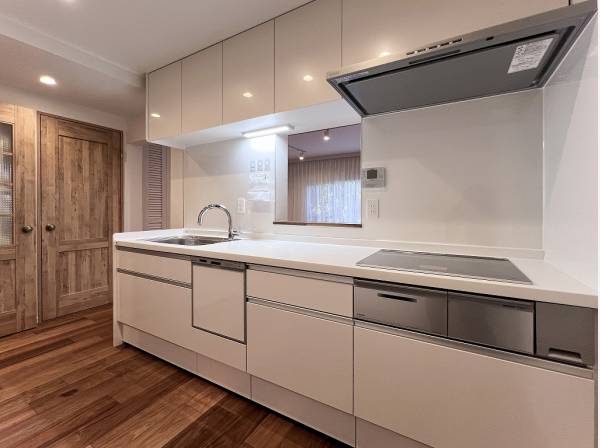 ホワイトのキッチンに木調の建具がバランスよく調和