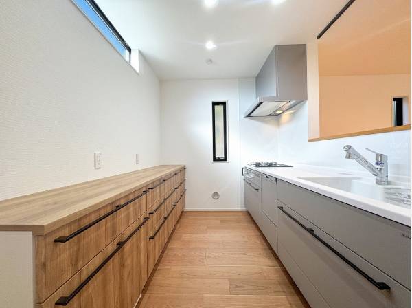 ウッド調のカップボードが備わった広いキッチン