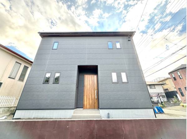 スタイリッシュなグレー調の建物外観。北東角地で開放感あふれる立地