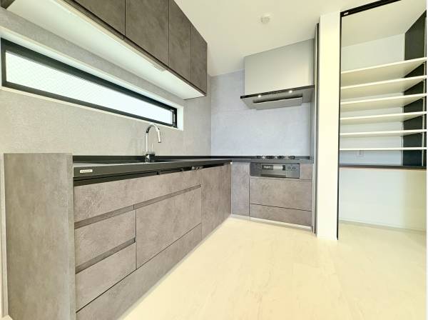 L字型のシステムキッチン。上部と隣に収納があり収納面も安心です。