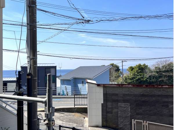 屋根の隙間から波音が聴こえてきそうなブルーの景色