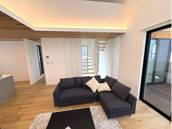 大きなソファでゆったり。スケルトン階段がアクセントのリビング