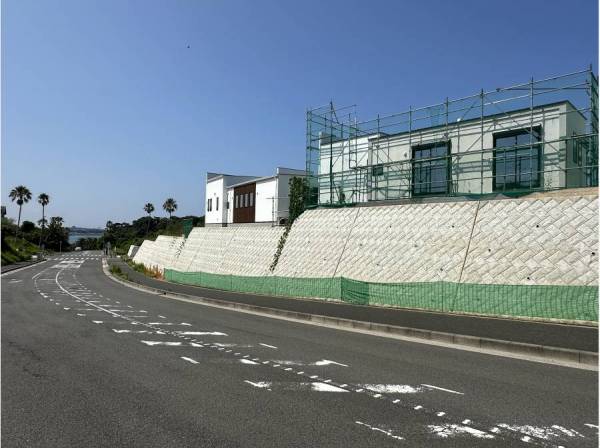 反対側から見た現地/抜け感はご覧の通りです/交通量の少ない道路