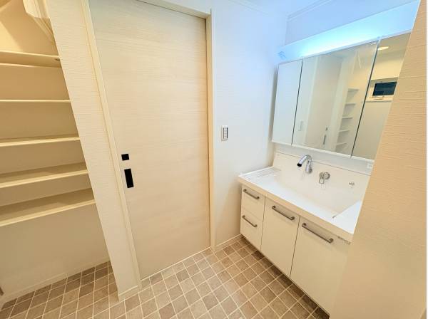 タオルや小物をすっきりしまえる収納棚付き。清潔感あふれる洗面室です