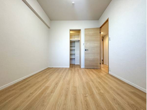 便利な棚付きのウォークインクローゼットを備えた洋室