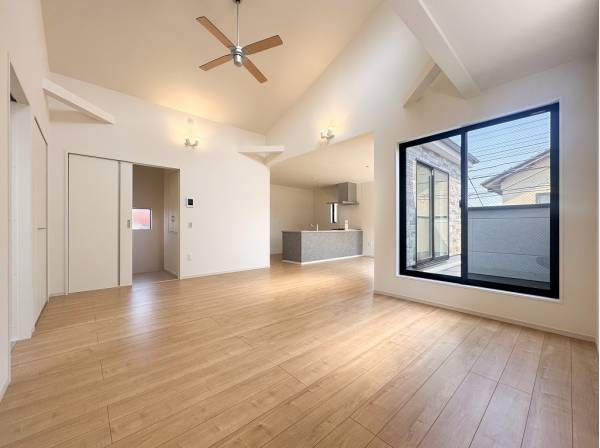 吹抜けの先でシーリングファンが回る開放的なリビング