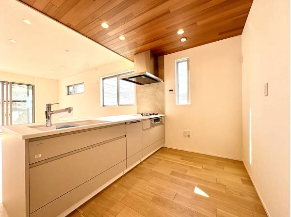 オープンで開放的なペニンシュラキッチン。キッチン天井はレッドシダーを採