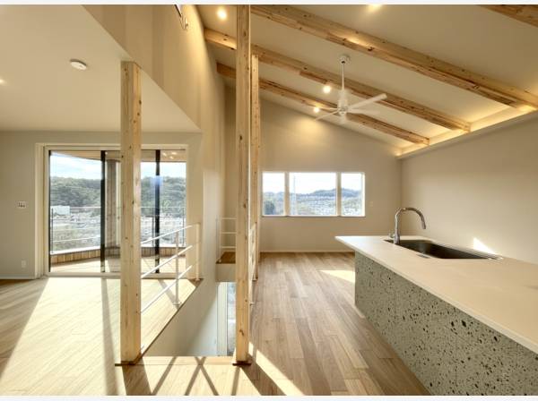 大谷石をあしらったオープントップのキッチンが主役のリビング